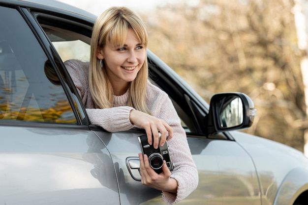 Beautiful blonde woman holding a vintage camera