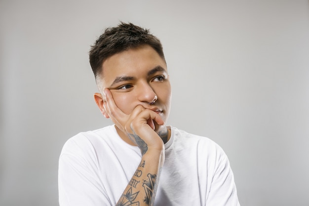 Beautiful bored man bored isolated on gray wall