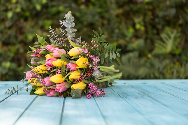 Beautiful bouquet on blue wooden surface