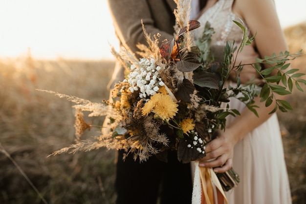 Beautiful bouquet of wild flowers in the hands of the bride