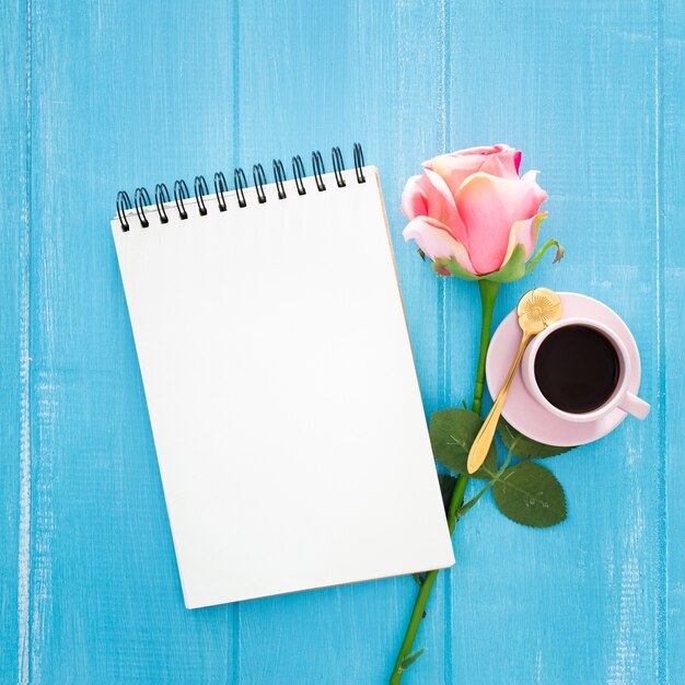 beautiful breakfast with roses and cup of coffee on blue wooden 