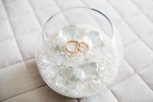 Free photo beautiful bride wedding rings are in a glass cup