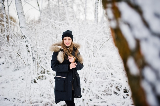 Free Photo beautiful brunette girl in winter warm clothing model on winter jacket and black hat