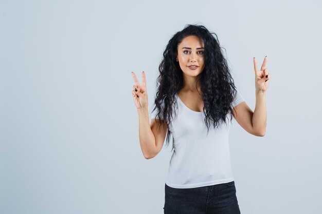 Beautiful brunette woman in a white t-shirt showing peace