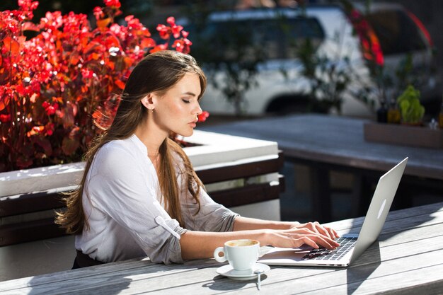 Beautiful brunette works with laptop outside