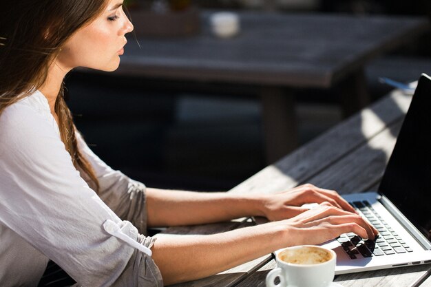 Beautiful brunette works with laptop outside