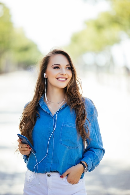 Beautiful brunette young woman wearing dress and walking on the street