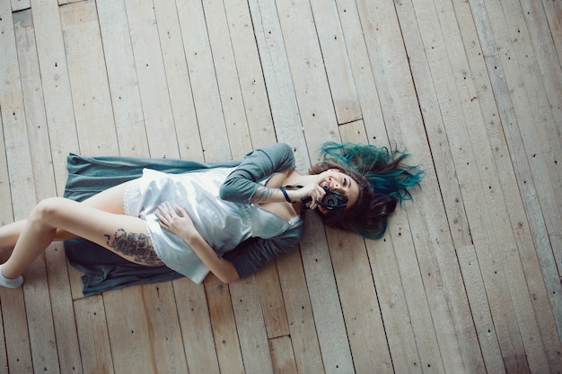 Free Photo beautiful carefree young casual woman lying on the wooden floor