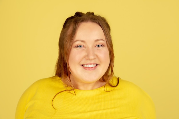 Free photo beautiful caucasian plus size model isolated on yellow studio background concept of inclusion human emotions facial expression