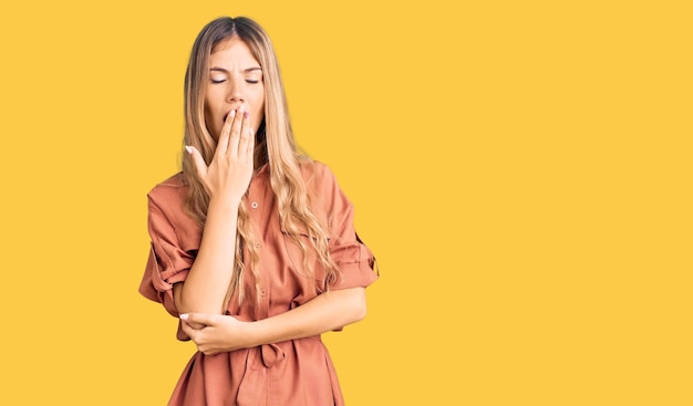 Free Photo beautiful caucasian woman with blonde hair wearing summer jumpsuit bored yawning tired covering mouth with hand. restless and sleepiness.