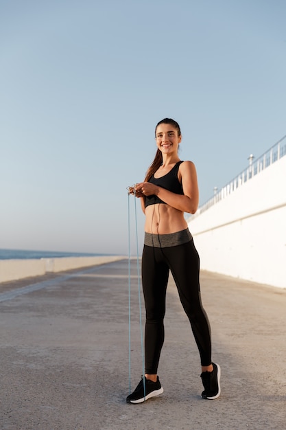 Beautiful cheerful woman with jumping rope training isolated