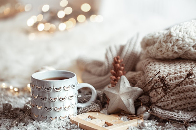 Beautiful Christmas cup with a hot drink on a light blurred background. The concept of home comfort and warmth.