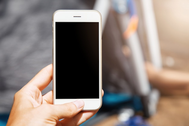 Beautiful close-up shot of modern white smartphone. Woman holding her up-to-date switched off gadget with her hand and pushing home button.