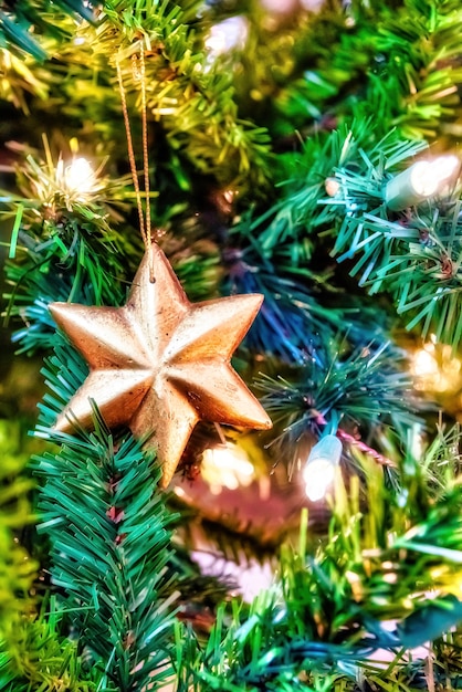 Free photo beautiful closeup of a golden ornament on a christmas tree with lights