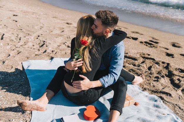 Free photo beautiful couple hugging happily on shoreline