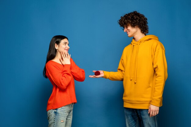 Beautiful couple in love on blue studio wall