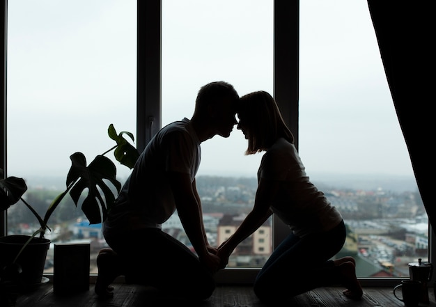 Free photo beautiful couple posing next to the window