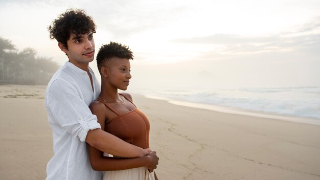 Free photo beautiful couple showing affection on the beach near the ocean