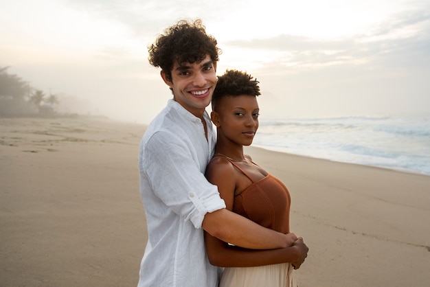 Free photo beautiful couple showing affection on the beach near the ocean