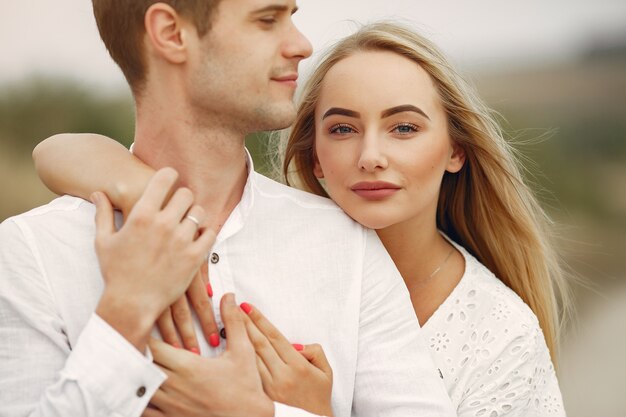 Beautiful couple spend time in a autumn field