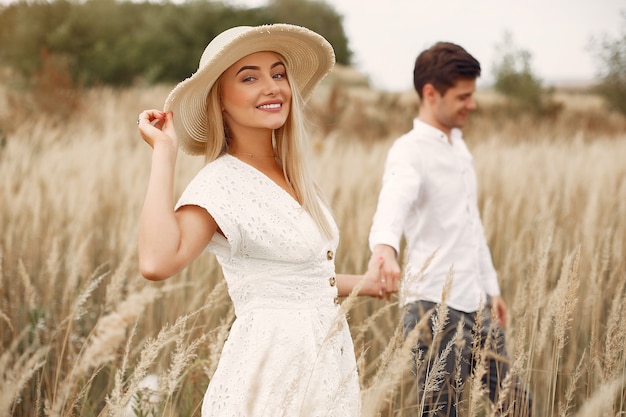 Beautiful couple spend time in a autumn field