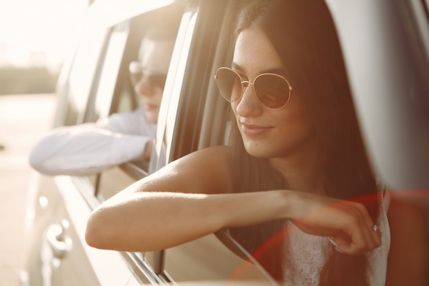 Free photo beautiful couple spend time in a summer park sitting in a car