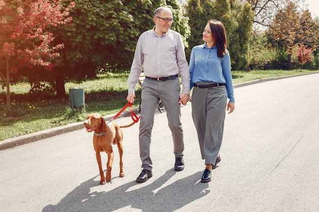 Beautiful couple in a summer forest with a dogs