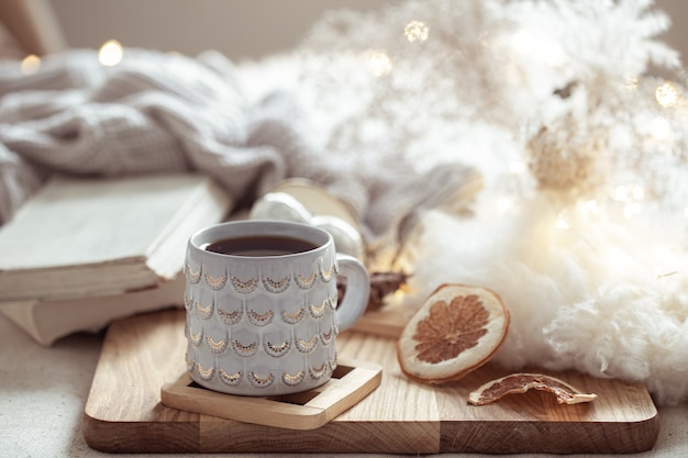 Free photo a beautiful cup with a hot drink on the background of cozy things. home comfort and warmth concept.