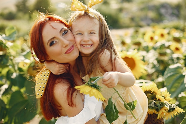 Beautiful and cute family in a field wirh sunflowers