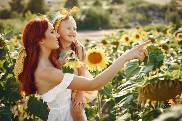 Beautiful and cute family in a field wirh sunflowers