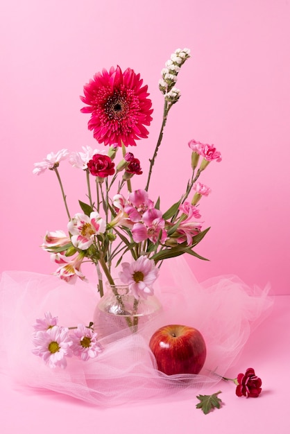 Beautiful different flowers and red apple