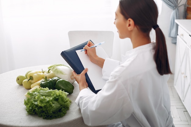 Free photo beautiful doctor in a kitchen with vegetables