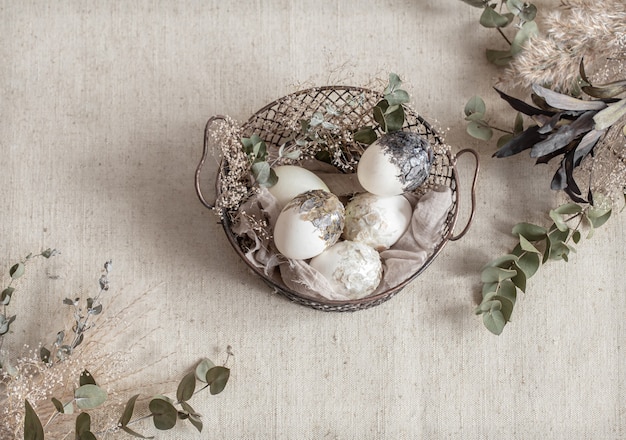 Free photo beautiful easter eggs in a basket decorated with dried flowers. happy easter concept.