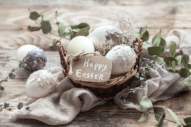 Beautiful Easter eggs in a basket decorated with dried flowers. Happy Easter concept.