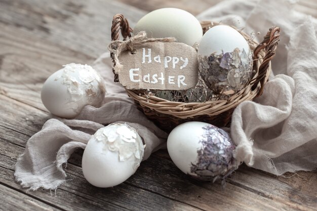 Beautiful Easter eggs in a basket decorated with dried flowers. Happy Easter concept.