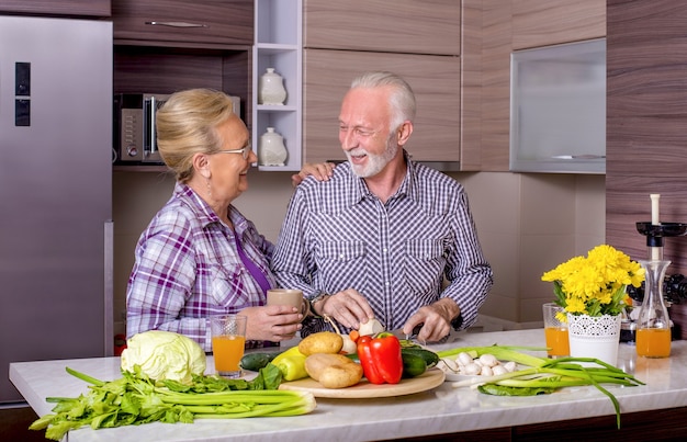 Free photo beautiful elderly couple cooking in the kitchen with each other