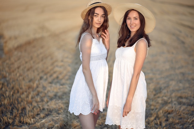 Free photo beautiful elegant girls in a autumn wheat field