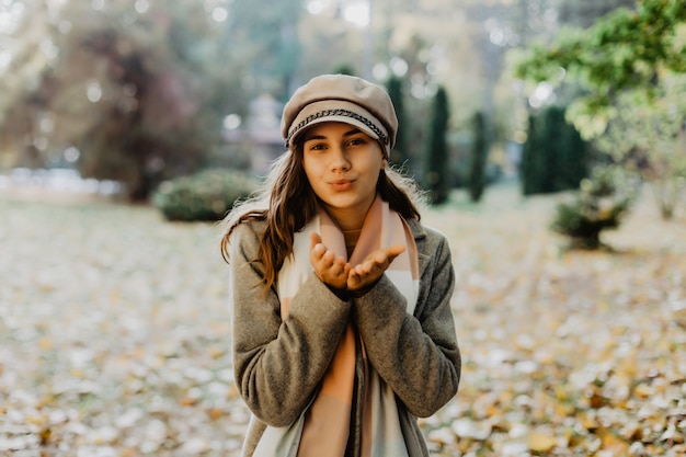 Beautiful elegant woman standing in park in autumn