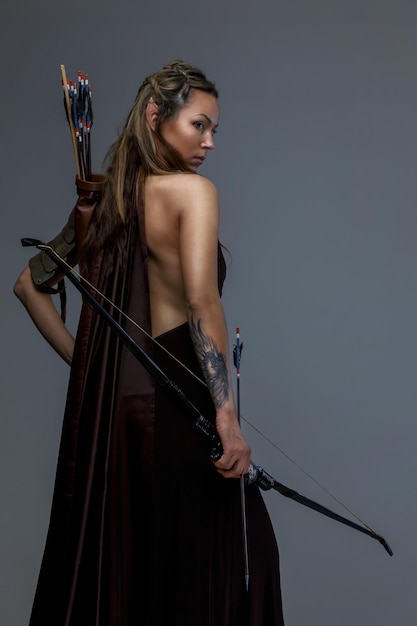 Free photo beautiful elf woman woth bow and arrows. isolated on grey