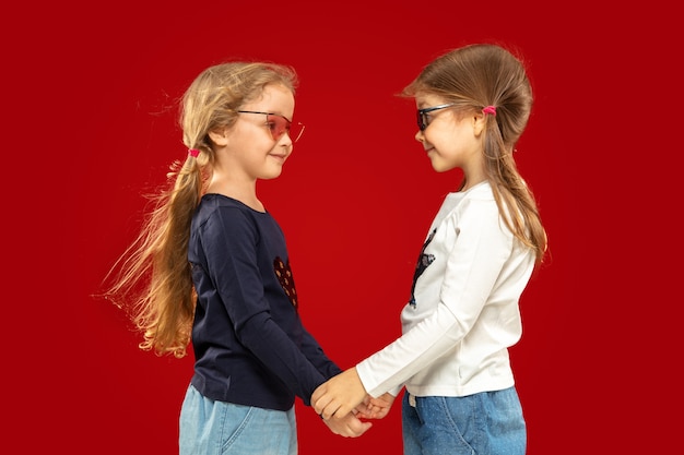 Free photo beautiful emotional little girl isolated on red