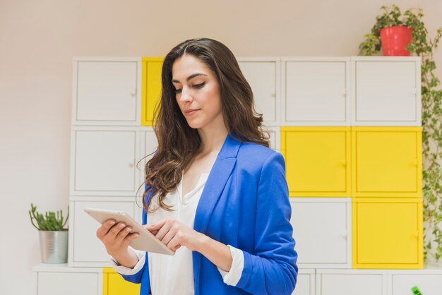 Beautiful employee checking her tablet in the office