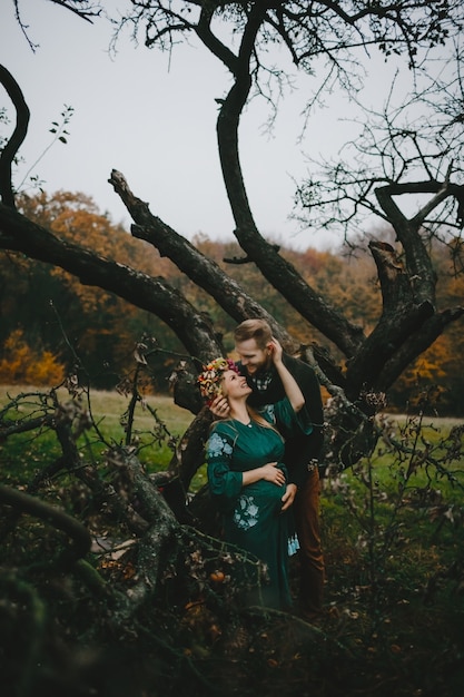 Free photo beautiful expecting woman and her man stand hugging outside