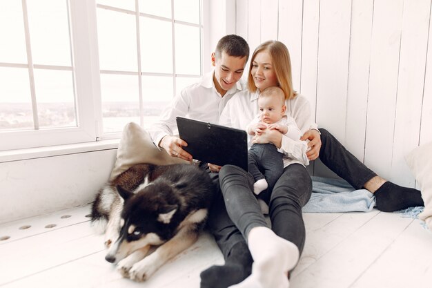 Beautiful family spend time in a bedroom with a tablet