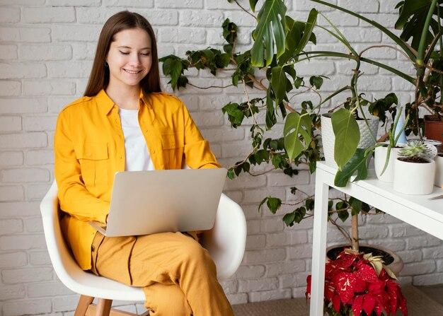 Beautiful female gardener working on her laptop