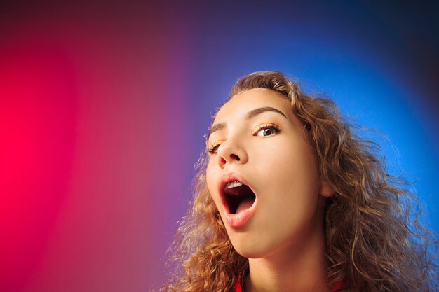 Beautiful female half-length front portrait on red and blue background.