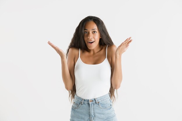 Beautiful female half-length portrait isolated on white studio background. Young emotional african-american woman with long hair. Facial expression, human emotions concept. Astonished, excited.