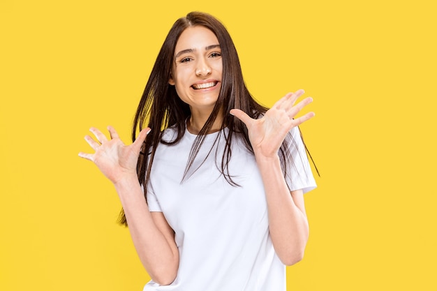 Beautiful female half-length portrait isolated on yellow  space. Young smiling woman. Facial expression, summer, weekend, resort concept