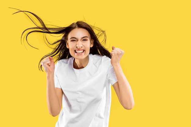 Beautiful female half-length portrait isolated on yellow studio