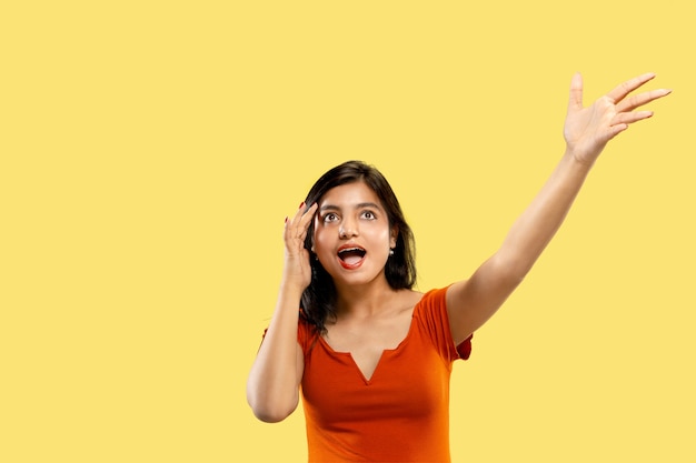 Beautiful female half-length portrait isolated on yellow