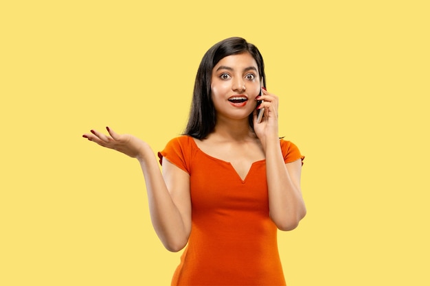 Beautiful female half-length portrait on yellow studio